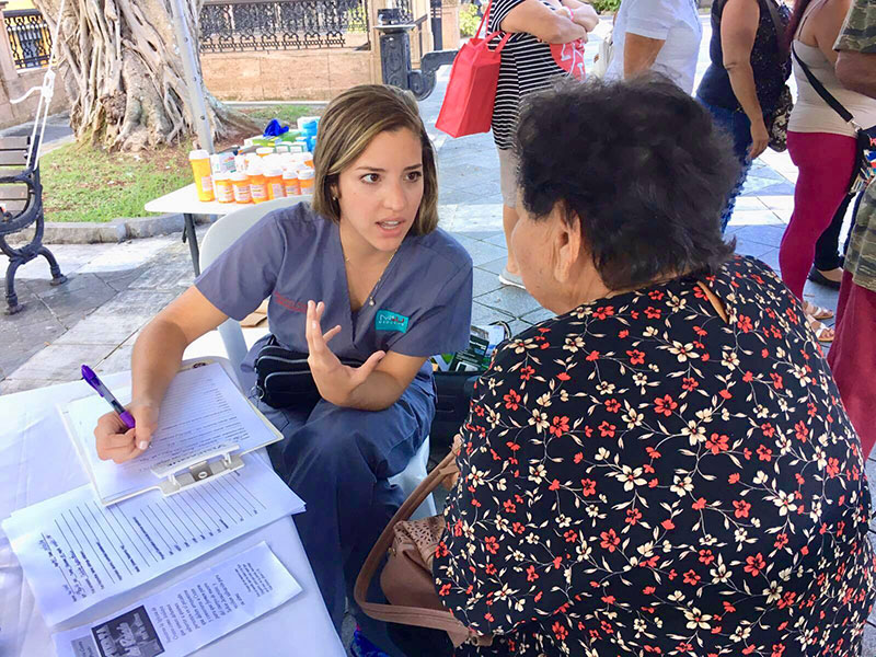 ARIANA HERNANDEZ WITH A PATIENT: Ms. Hernandez at work at one of the clinics. Photo: UMHS Med4You