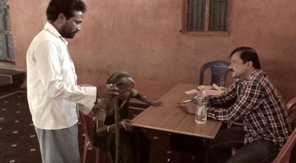 AT WORK IN INDIA: Dr. Mungli ( seated) helping patients. Photo: Courtesy of Dr. Prakash Mungli