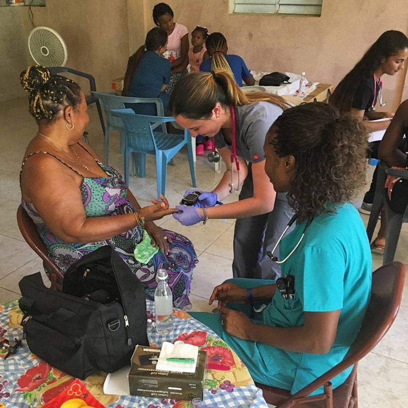 UMHS students Natalie Vera & Charmaine Trotman-Shumantov check a patient's blood sugar in La Caleta, Boca Chica, Dominican Republic. Photo: UMHS Med4You