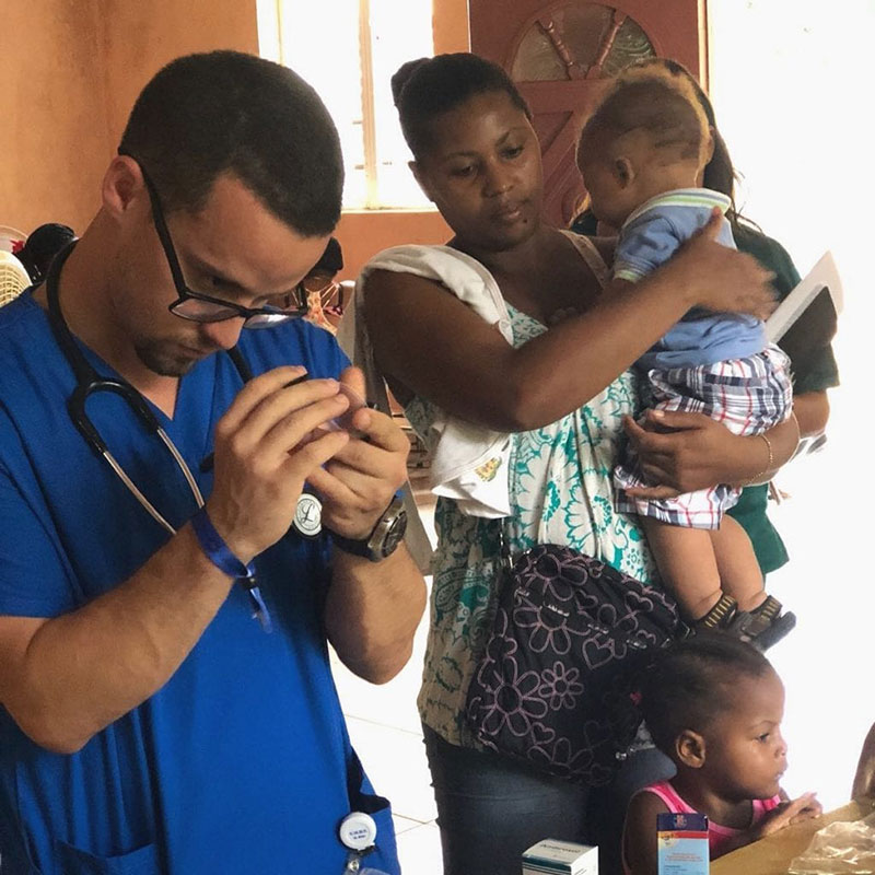 Luis Adorno, UMHS Med4You Chapter President, at work while patients wait at the La Caleta, Boca Chica clinic in the Dominican Republic. Mr. Adorno was the student leader & worked very hard in fundraising for the benefit of this community. Photo: UMHS Med4You