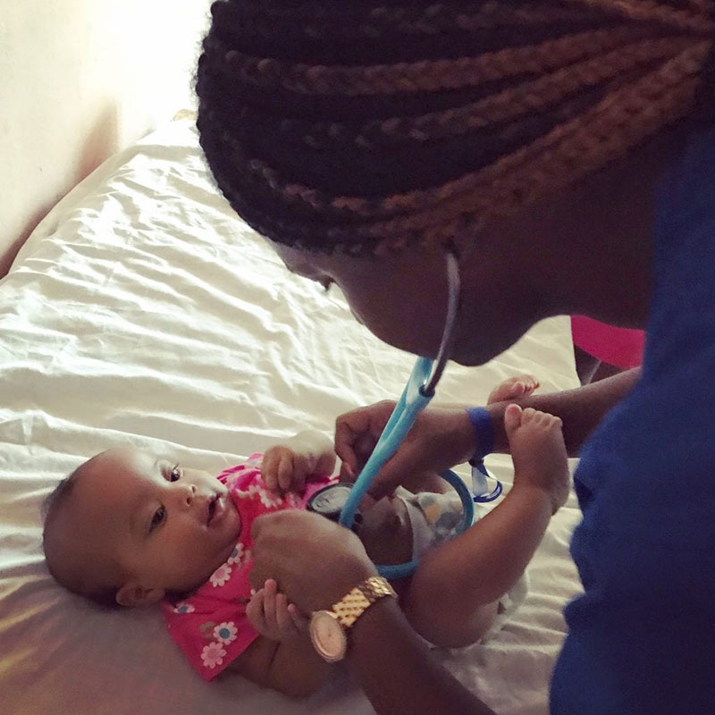 UMHS student Pryia Simmons examines a baby in La Caleta, Boca Chica, Dominican Republic. Photo: UMHS Med4You