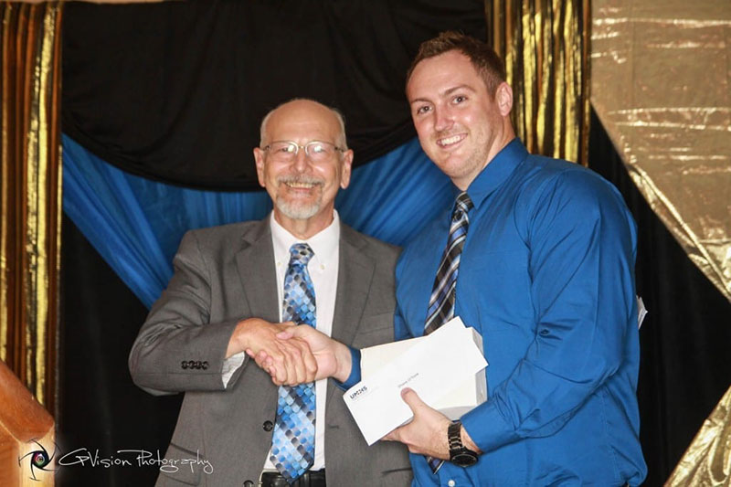 UMHS DEAN & WINNER: Edwin Purcell, PhD, UMHS Associate Dean of Academic Affairs & Professor of Anatomy and Professor of Histology, gives Dr. Robert Ross Scholar Award to Shane O’Toole, the top student by academic rank. Photo: GP Vision Photography