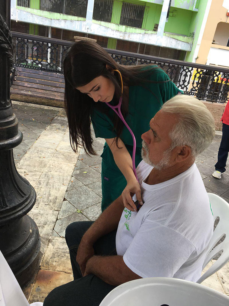 Fabiola Ramos (UMHS EBS5 student/Med4You member) helps a patient during the Arecibo, Puerto Rico free health clinic. Photo: UMHS Med4You