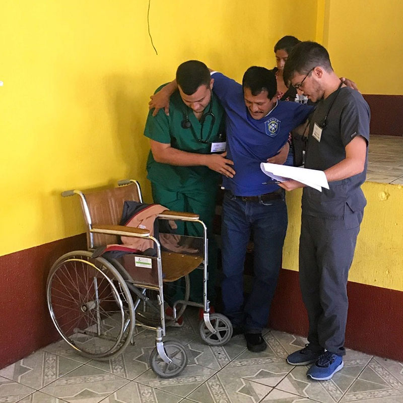 HELPING IN UNDERSERVED AREAS: Inspired by the amazing experiences UMHS students have had on Med4You medical mission trips (pictured), Dr. Angel Matos established the UMHS Global Health Institute to train students in Global Health & contribute to reduce health disparities in the world. Med4You president David Rivera (in green scrubs) helps a patient during a recent medical mission trip. Dr. Matos plans to have trips to the Philippines, Ethiopia & India in the future. Photo: UMHS