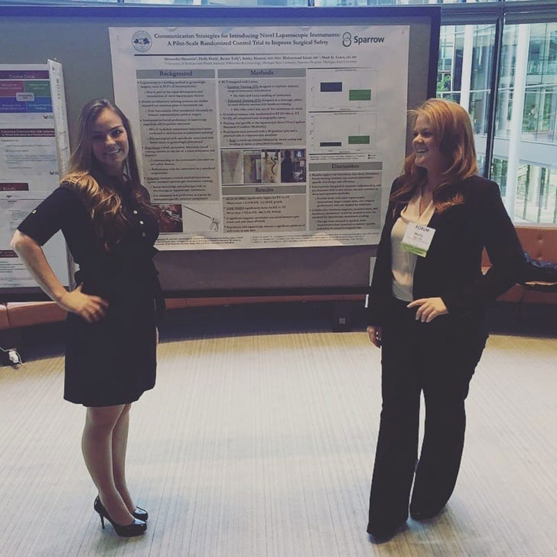 IN FRONT OF THEIR RESEARCH POSTER: Holly Huth & Renee Tolly at Yale. Photo: Courtesy of UMHS students