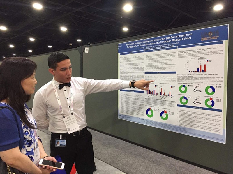 An attendee at the ASM meeting in Atlanta speaks with UMHS student Fernando J. Vélez Alfaro (right) about the MRSA study. Photo: Courtesy of Dr. Jane Harrington