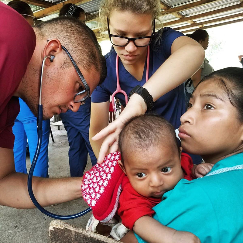 UMHS professor Dr. Angel Matos & UMHS student Yomarie Gonzalez (top) helping a baby in need in Cerro Grande, Guatemala in August 2017. Photo: UMHS Med4You