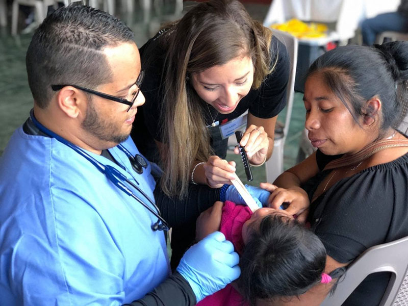 Med4You members Jann Vale & Ariana Hernandez helping a child & her mother in Magdalena Milpas Altas, Guatemala. Photo: UMHS Med4You