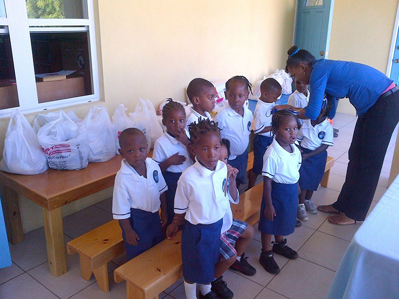 Holy Spirit Catholic Preschool children & teacher with donated food on the table