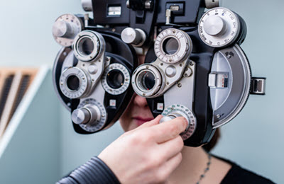 eye examination with a phoropter performed by an optometrist or an ophthalmologist