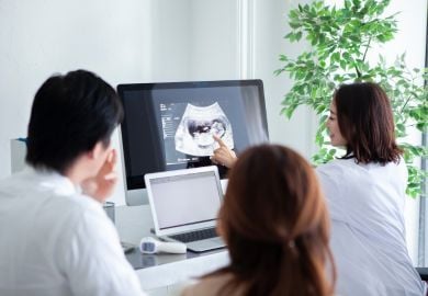 obgyn-shows-couple-sonography-of-baby-on-computer
