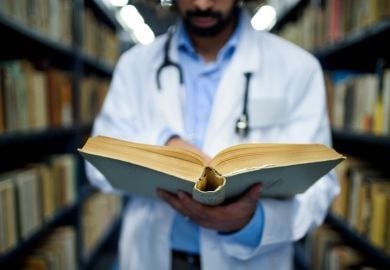 older-medical-student-referencing-a-book