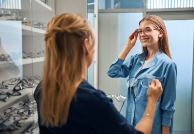 optician-selecting-glasses-for-customer-to-try-on