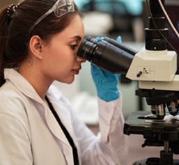 pathologist-at-microscope-with-slide