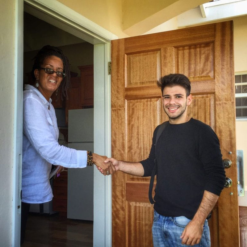 In a scene repeated dozens of times this week, a new UMHS student meets his landlord as he arrives at his new apartment in St. Kitts. Photo: Sean Powers